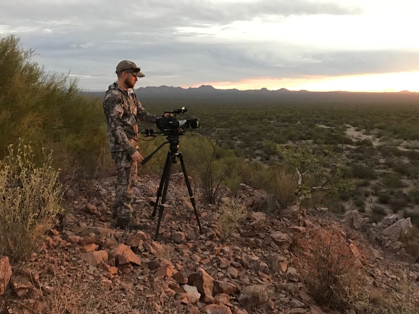 Camera operator overlooking the desert at dusk